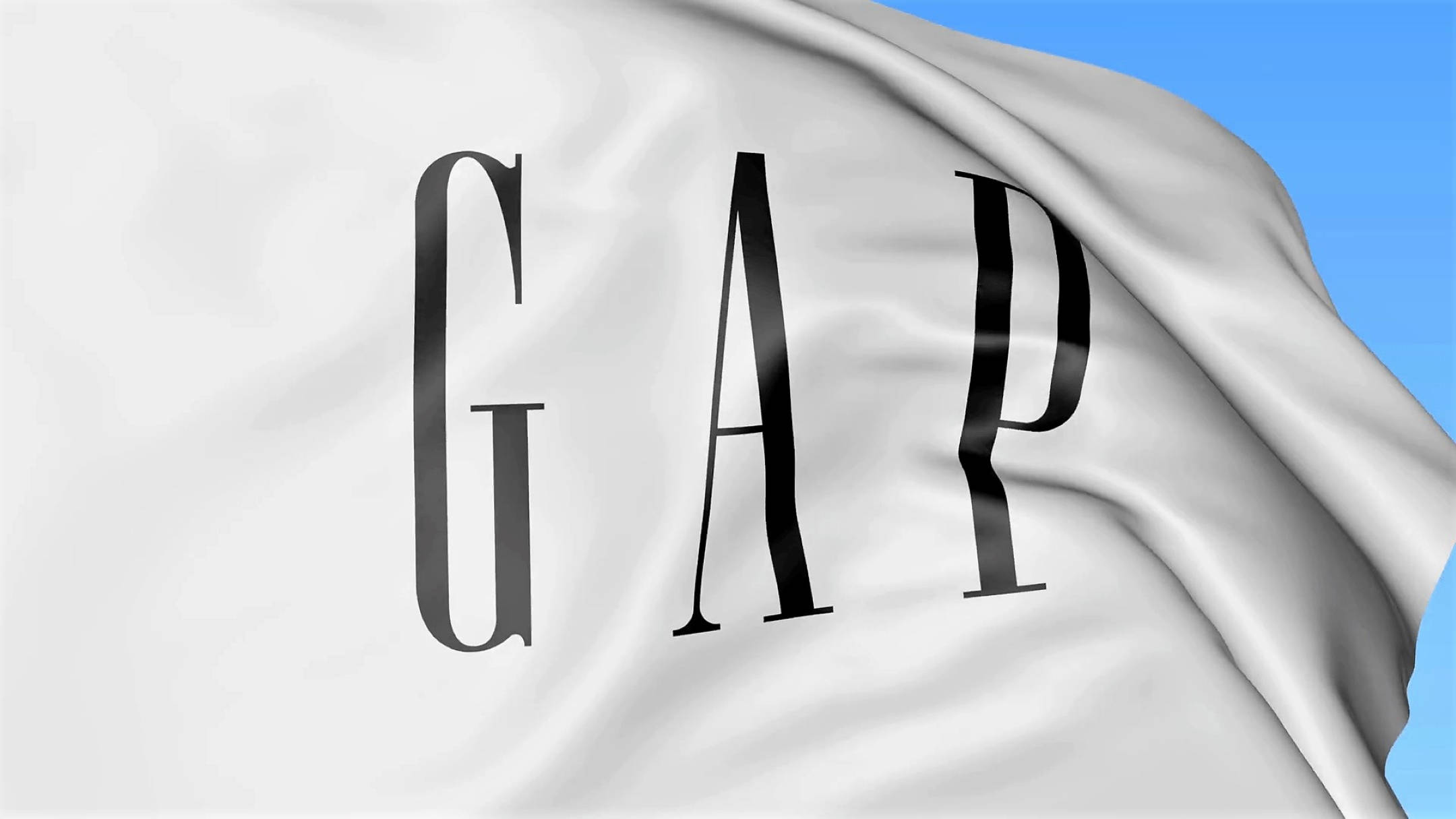 白色Gap旗幟藝術 壁紙 — 一面白色GAP旗幟，印有粗體黑色字母，在晴朗藍天下隨風飄揚。