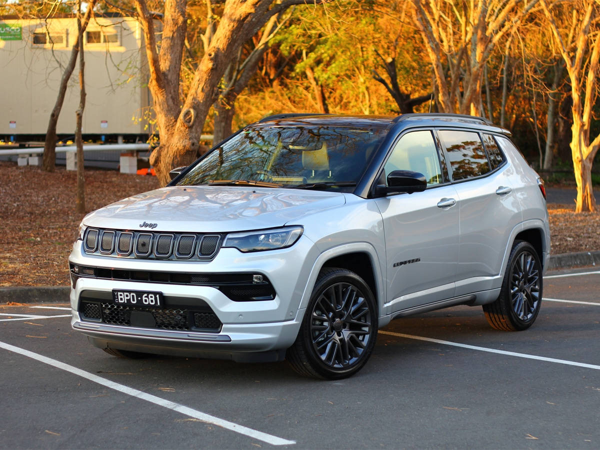銀色Jeep Compass停泊在停車場，背景有秋樹。