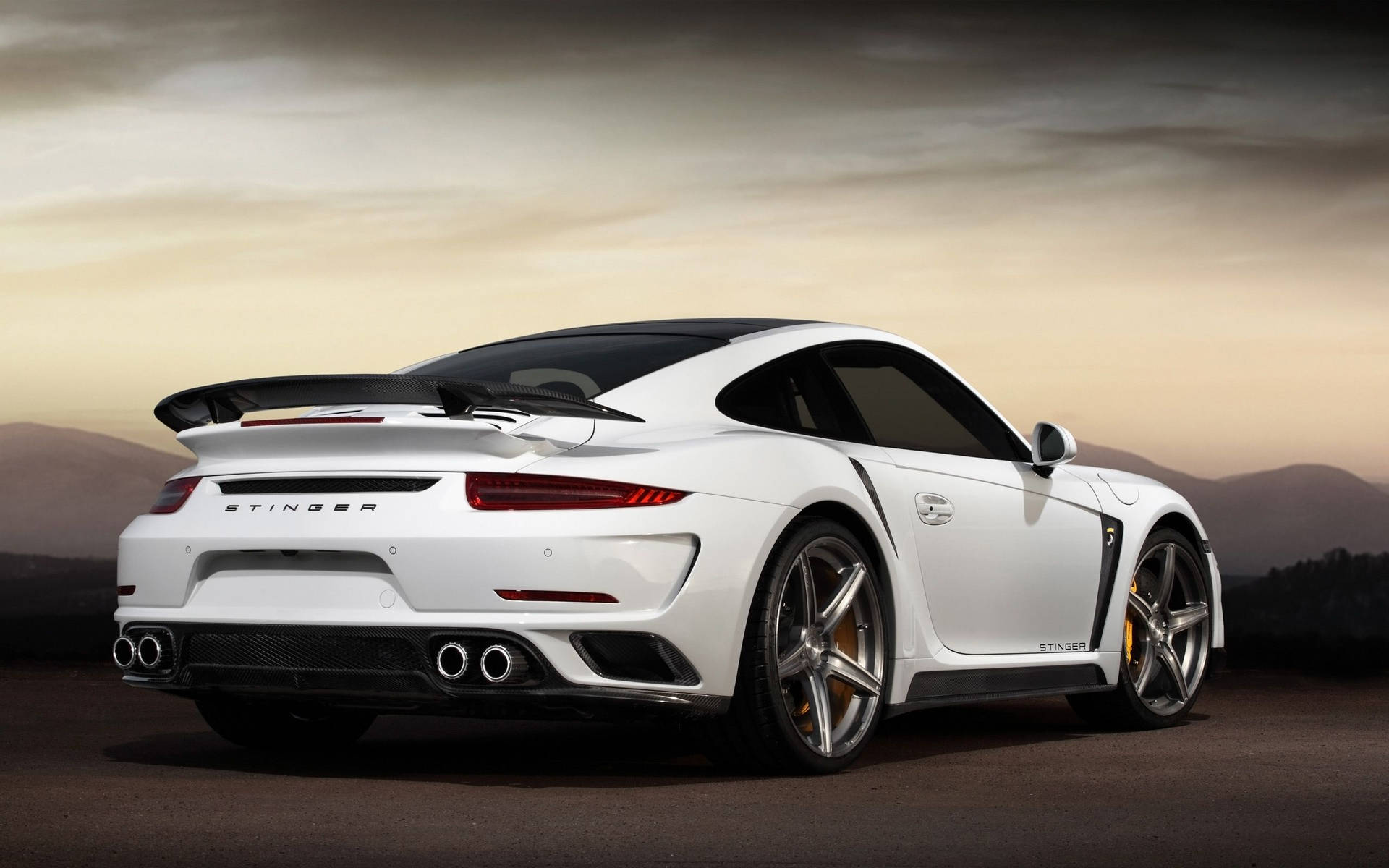 白色保時捷911 Turbo S Stinger在日落時分的沙漠公路上。