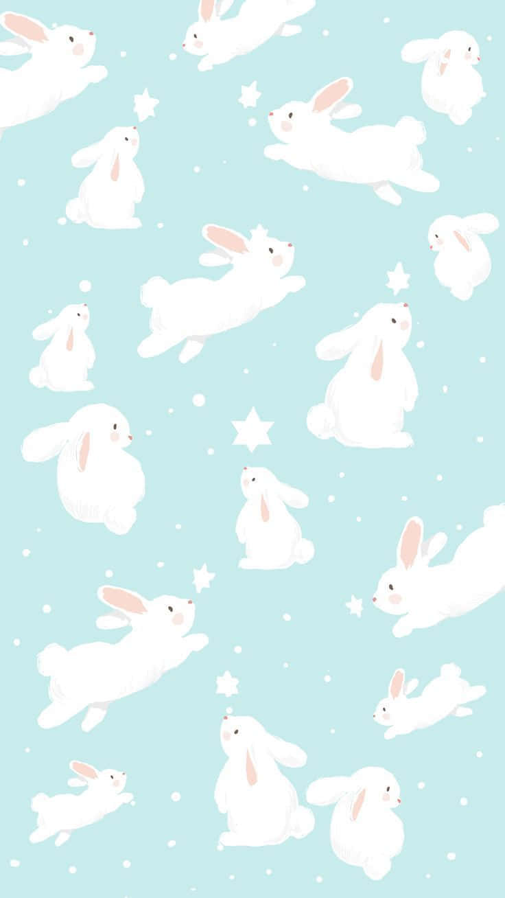 Kawaii Bunny 桌布 壁紙 — 白色卡通兔仔喺點綴住星星同雪花嘅柔和藍色背景上輕輕漂浮。