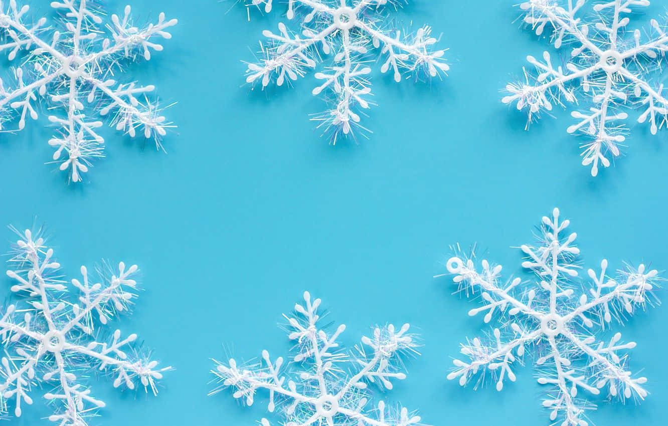 Winter Blues 桌布 壁紙 — 白色塑膠雪花排列在純藍色背景上的邊框。