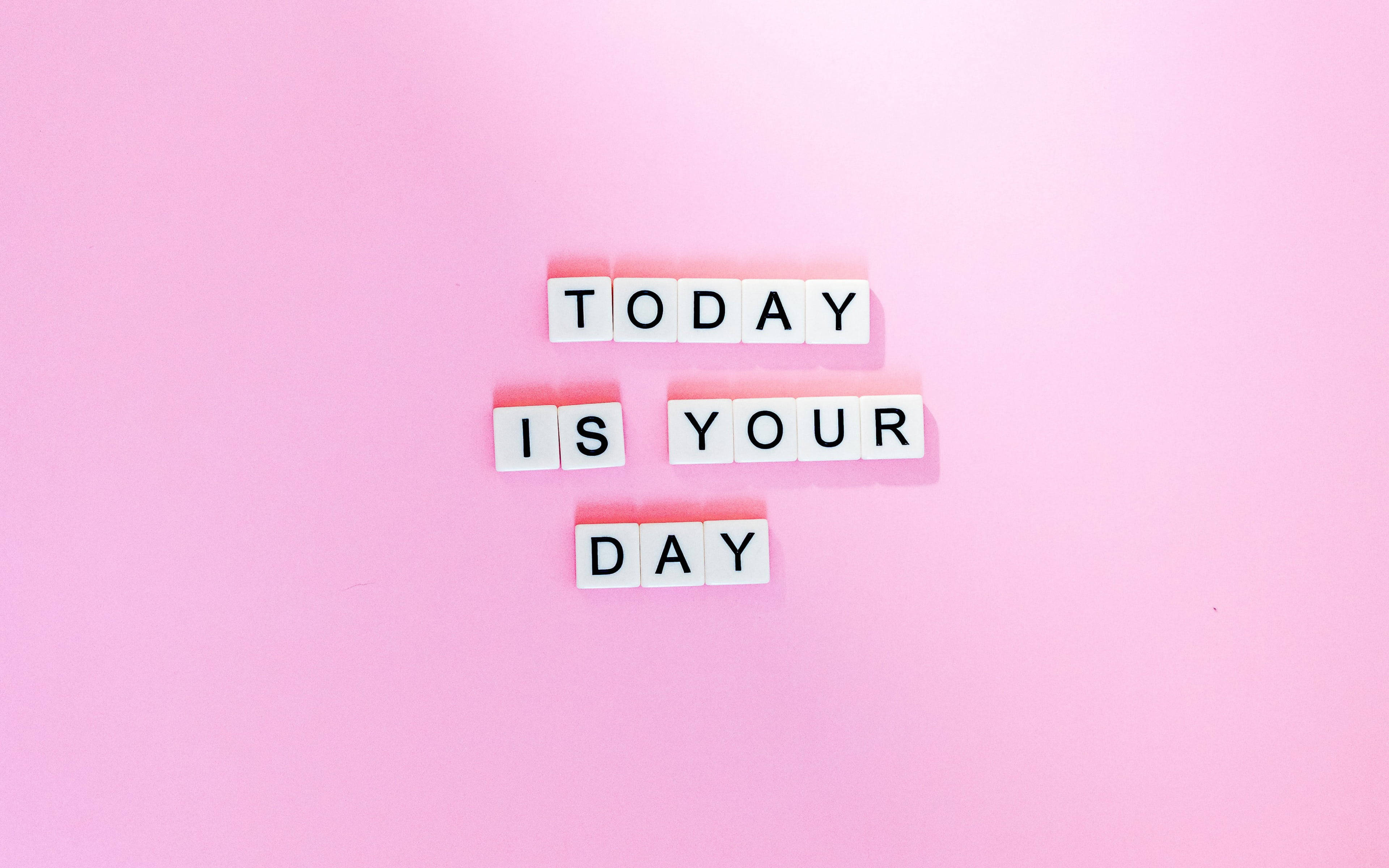 勵志語錄 桌布 壁紙 — 白色字母磚在柔和的粉紅色背景上拼出「TODAY IS YOUR DAY」。