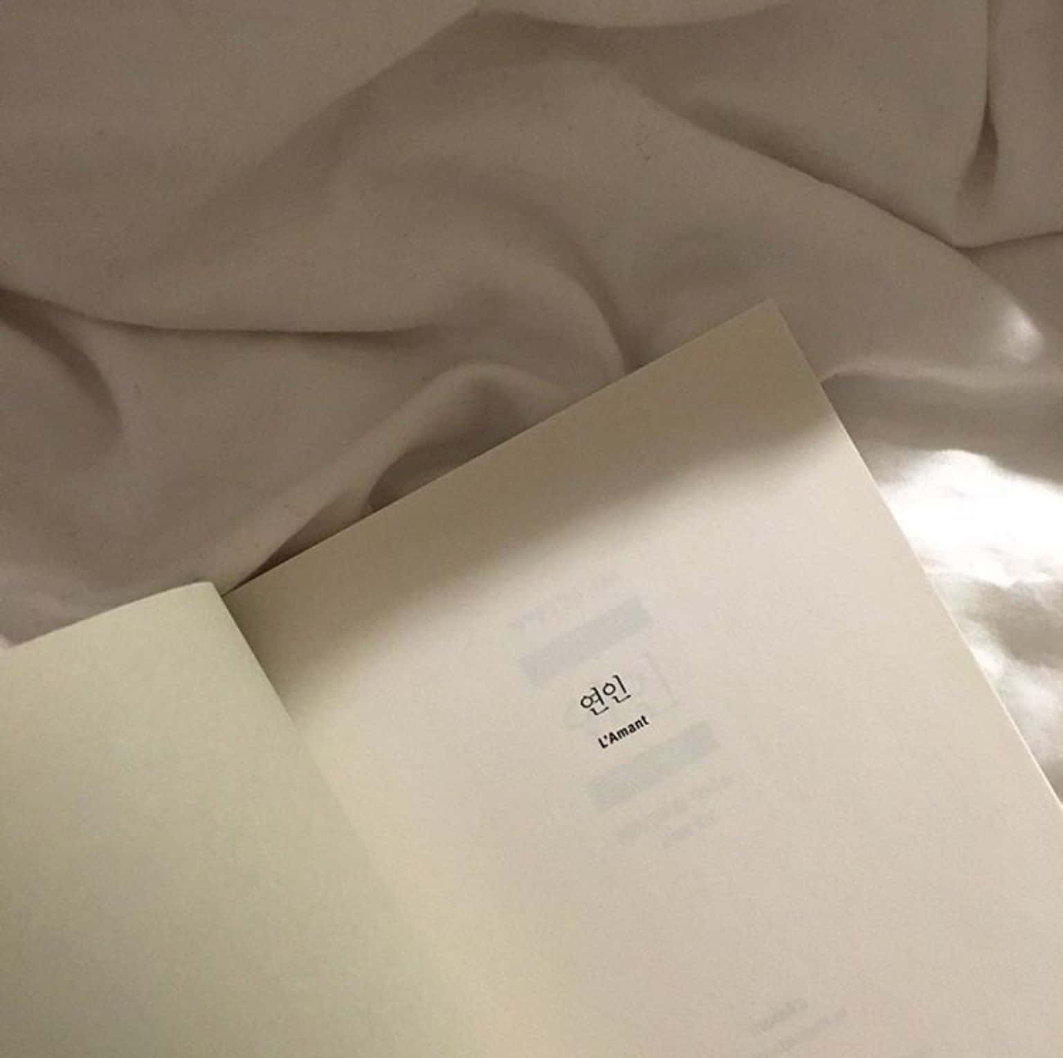 白色封面的書本放在床上 壁紙