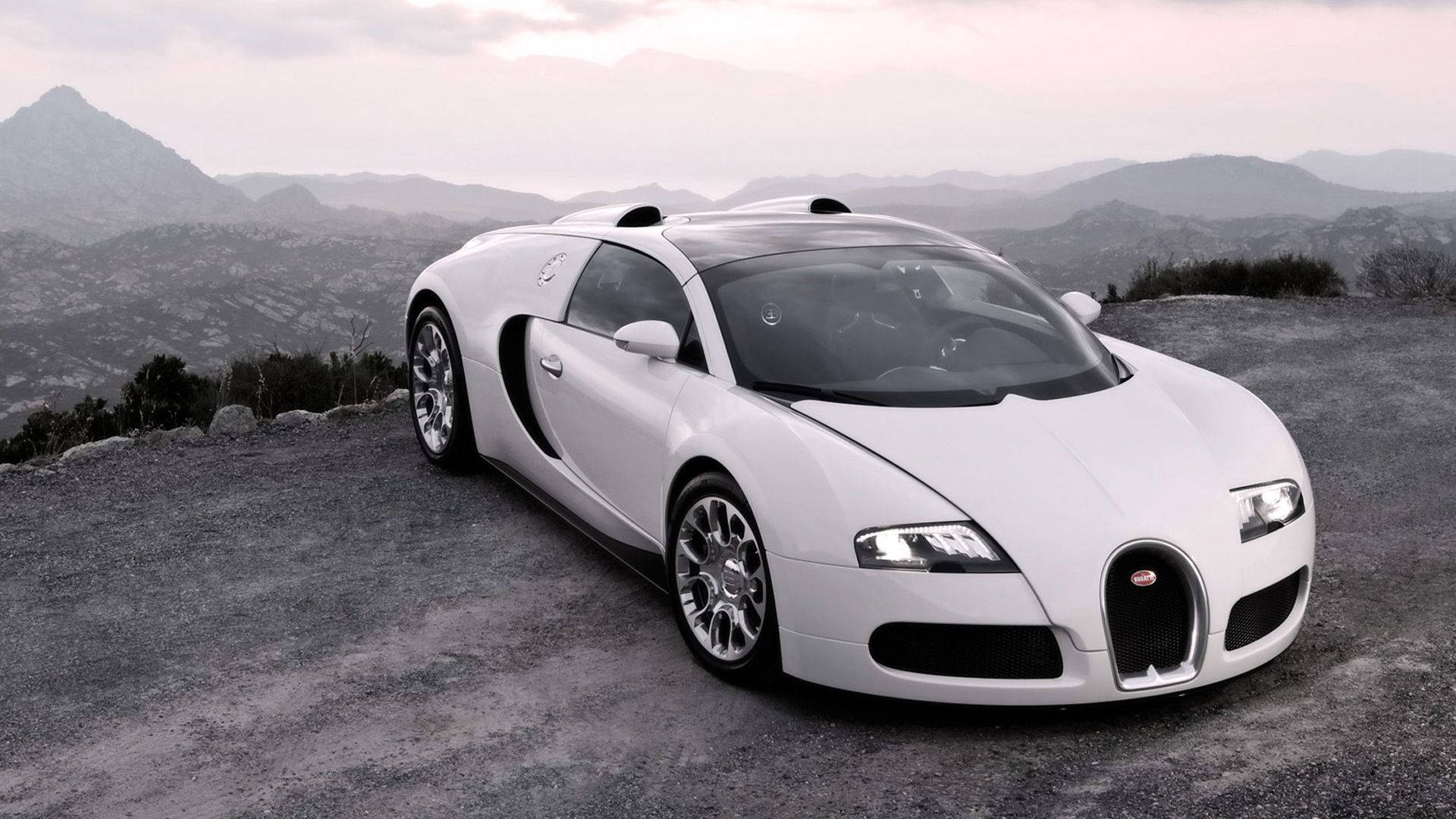 白色Bugatti Veyron在山路上，遠處有山丘