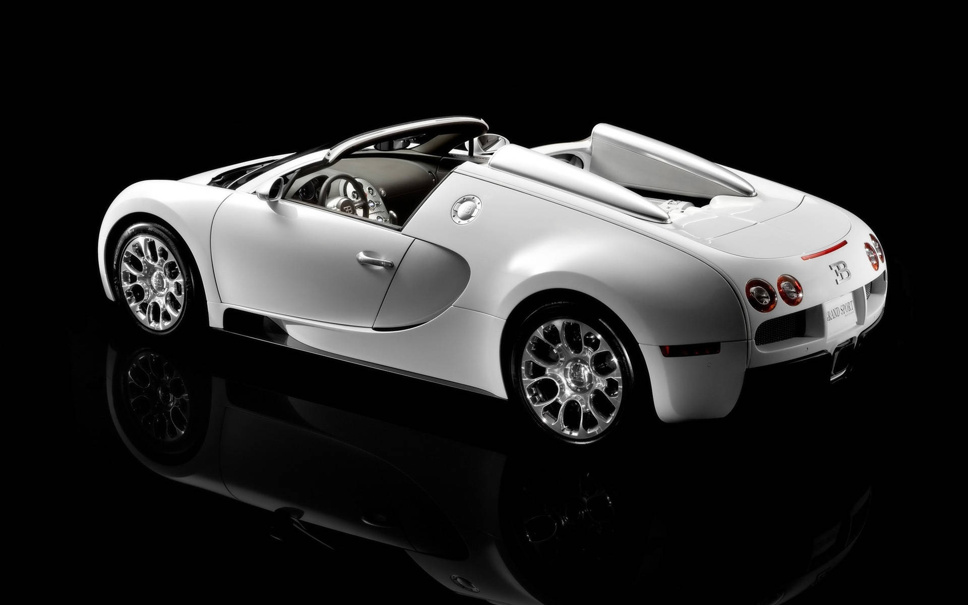 白色Bugatti Veyron Grand Sport開篷跑車在反光黑色表面上。