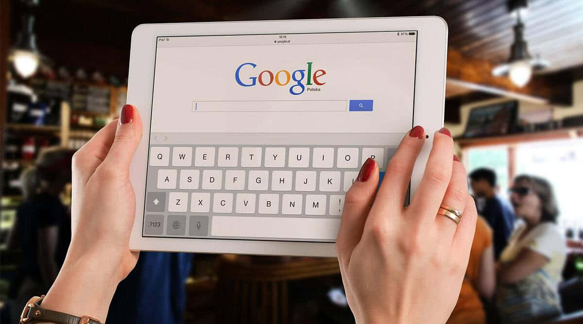 在咖啡店使用平板電腦搜尋Google的人。