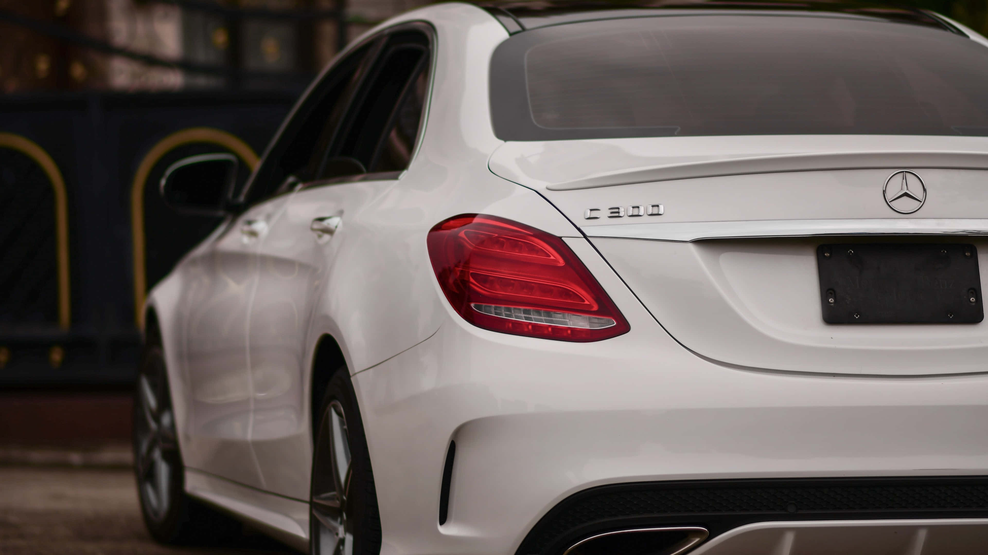 4K Mercedes 桌布 壁紙 — 白色平治C300房車的車尾特寫，展示其尾燈標誌和光澤飾面。