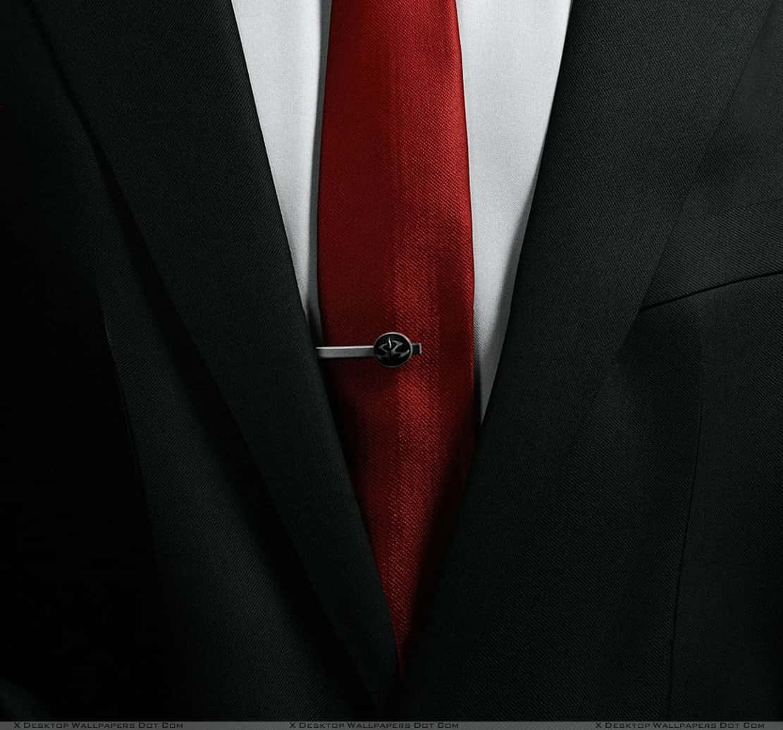 Red Tie 桌布 壁紙 — 白色恤衫背景下，黑色尖挺西裝搭配大膽紅色領帶和銀色領帶夾的特寫。
