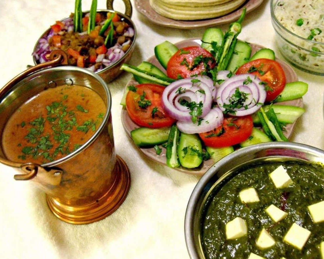 Indian Food 桌布 壁紙 — 白色枱布上擺放著色彩繽紛的印度菜餚，包括牛油雞、菠菜芝士和新鮮蔬菜沙律。