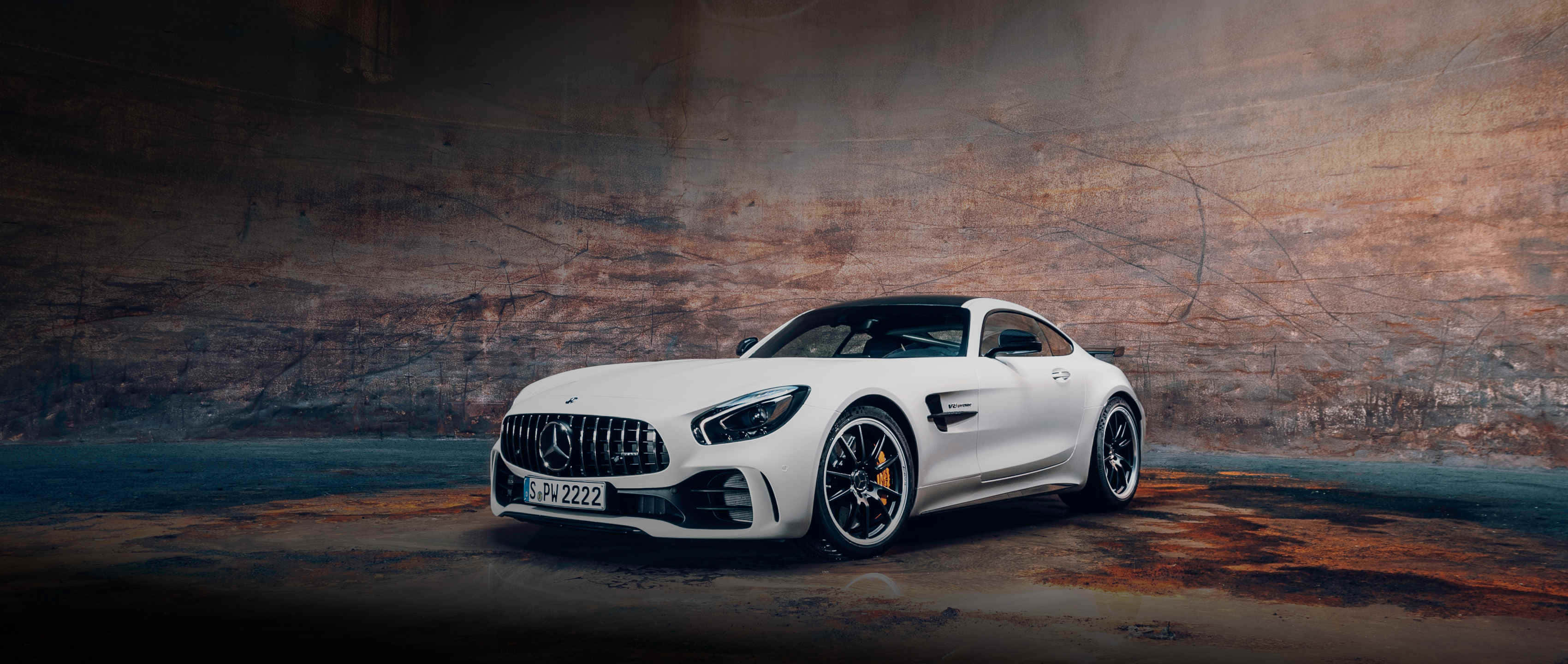 白色梅賽德斯AMG GT R洞穴背景 壁紙 — 一輛時尚的白色Mercedes-AMG GT停放在粗糙的工業隧道中，帶有戲劇性的燈光。