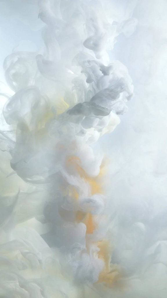 水中帶有白色和金色色調的抽象旋轉墨水雲。