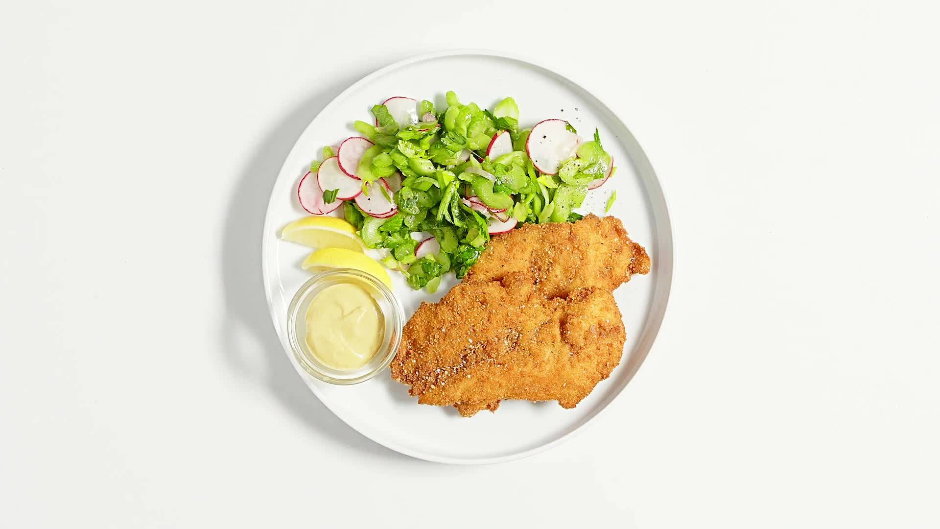 白色盤子上的維也納炸肉排 壁紙 — 金黃色炸肉排配新鮮蘿蔔生菜沙律及檸檬角，盛載於白色碟上。