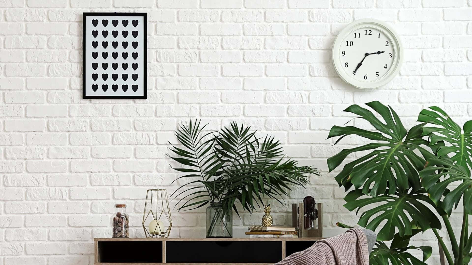 白色磚牆上掛有植物、時鐘和藝術品，營造現代家居風格。
