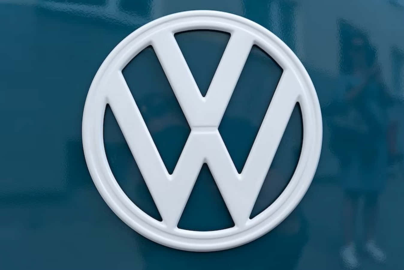 Logo 桌布 壁紙 — 白色福士汽車標誌的特寫，位於光澤藍綠色引擎蓋上，背景反射模糊。