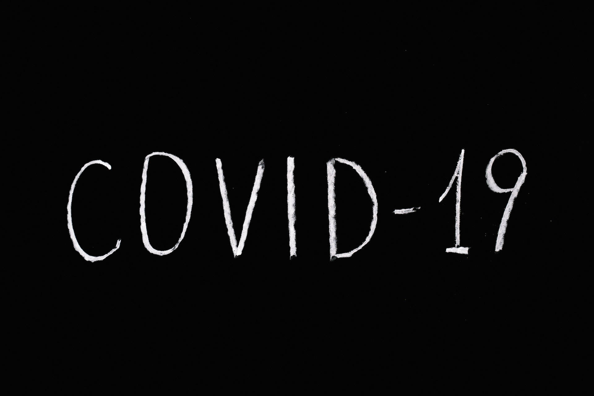 黑色動態圖 桌布 壁紙 — 白色粉筆在純黑背景上寫下的COVID-19字樣。
