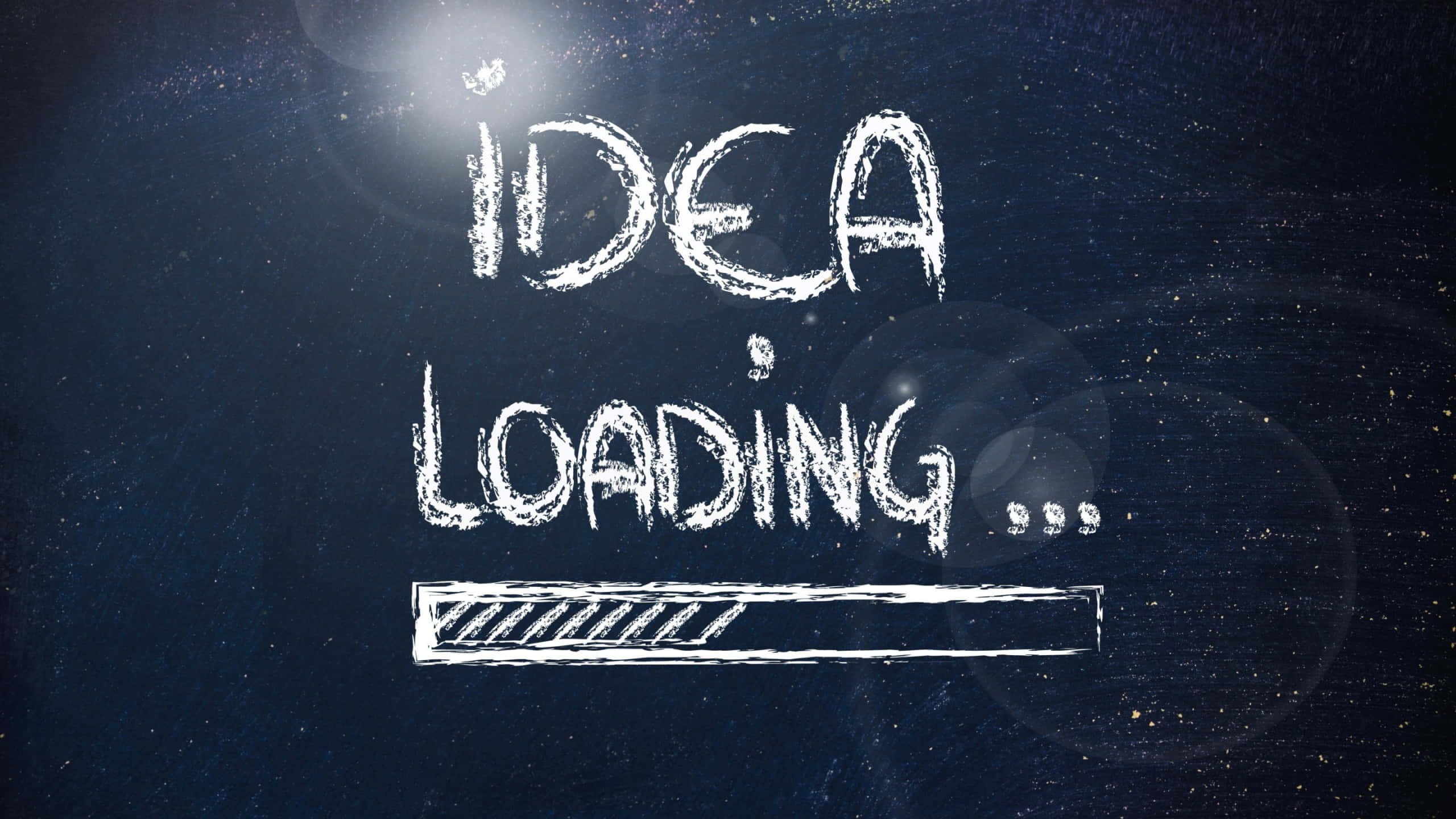 載入中 桌布 壁紙 — 白色粉筆文字寫著「IDEA LOADING...」，並在深色紋理表面上帶有進度條和鏡頭光暈。