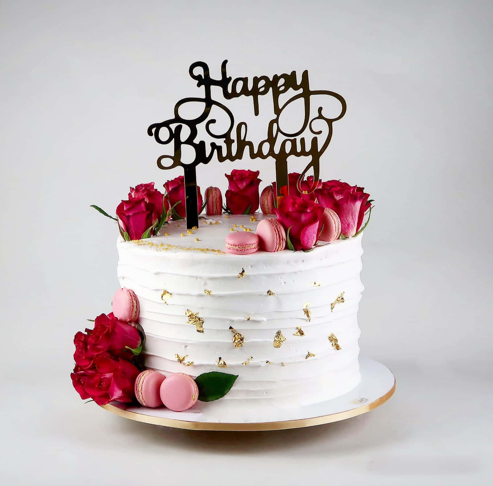 生日蛋糕 桌布 壁紙 — 白色糖霜生日蛋糕，飾有紅玫瑰、粉紅馬卡龍和金箔，配上黑色Happy Birthday插牌。