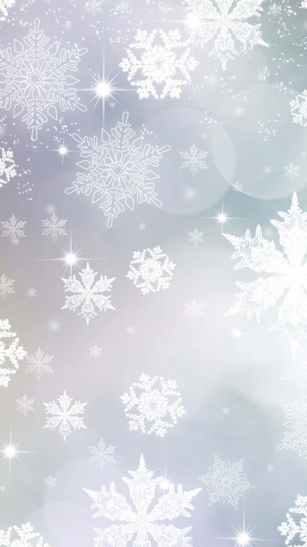 雪花伴隨著星芒和柔和的散景光在冬日天空中飄落。