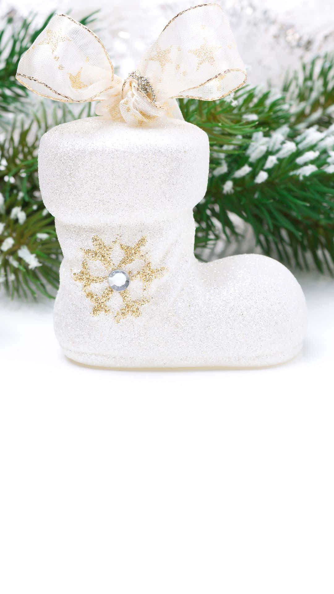 白色閃亮聖誕襪，帶金色雪花和蝴蝶結，背景是雪松枝。