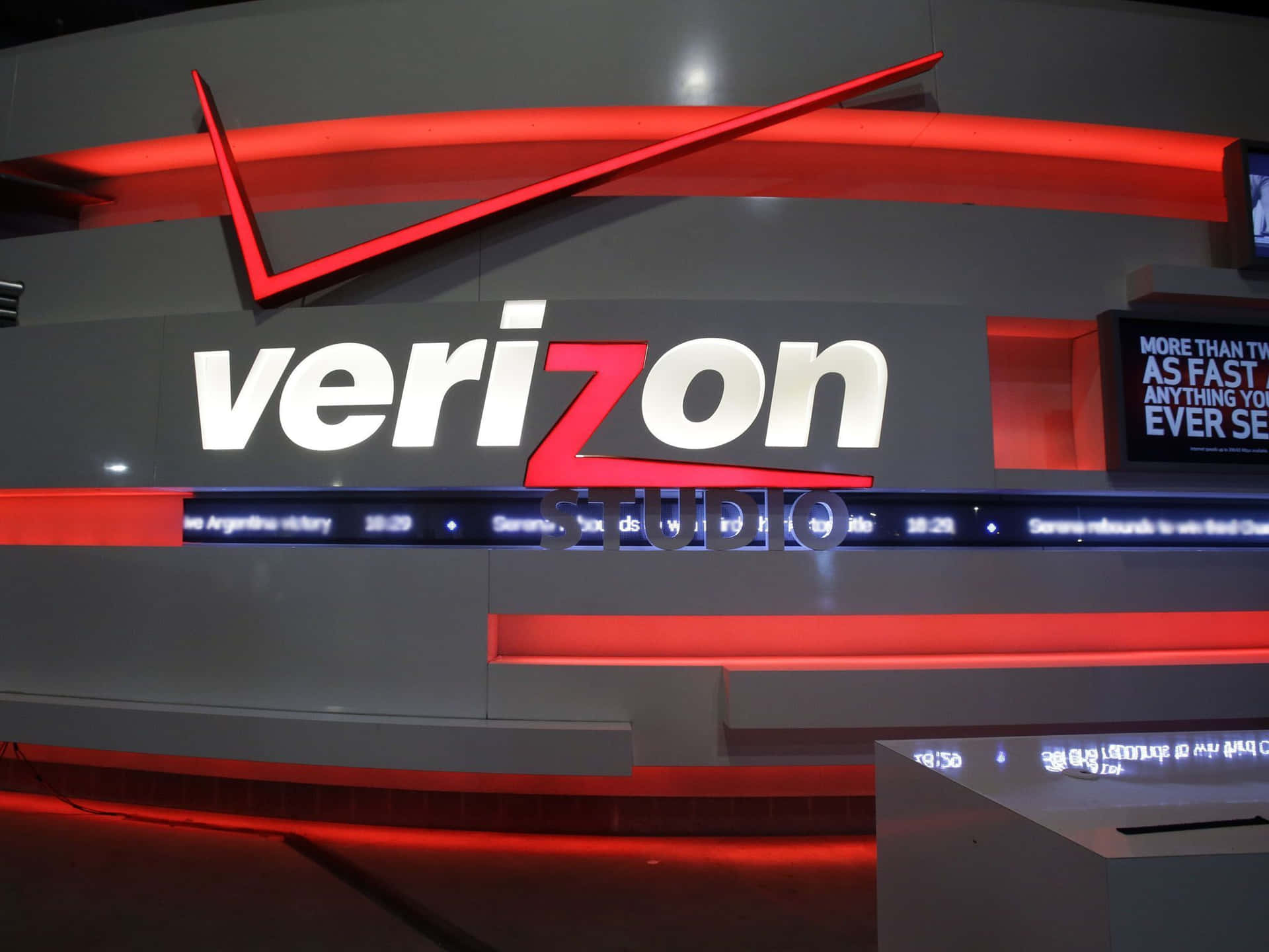科技展覽中帶有紅色和白色燈光的Verizon Studio標誌。