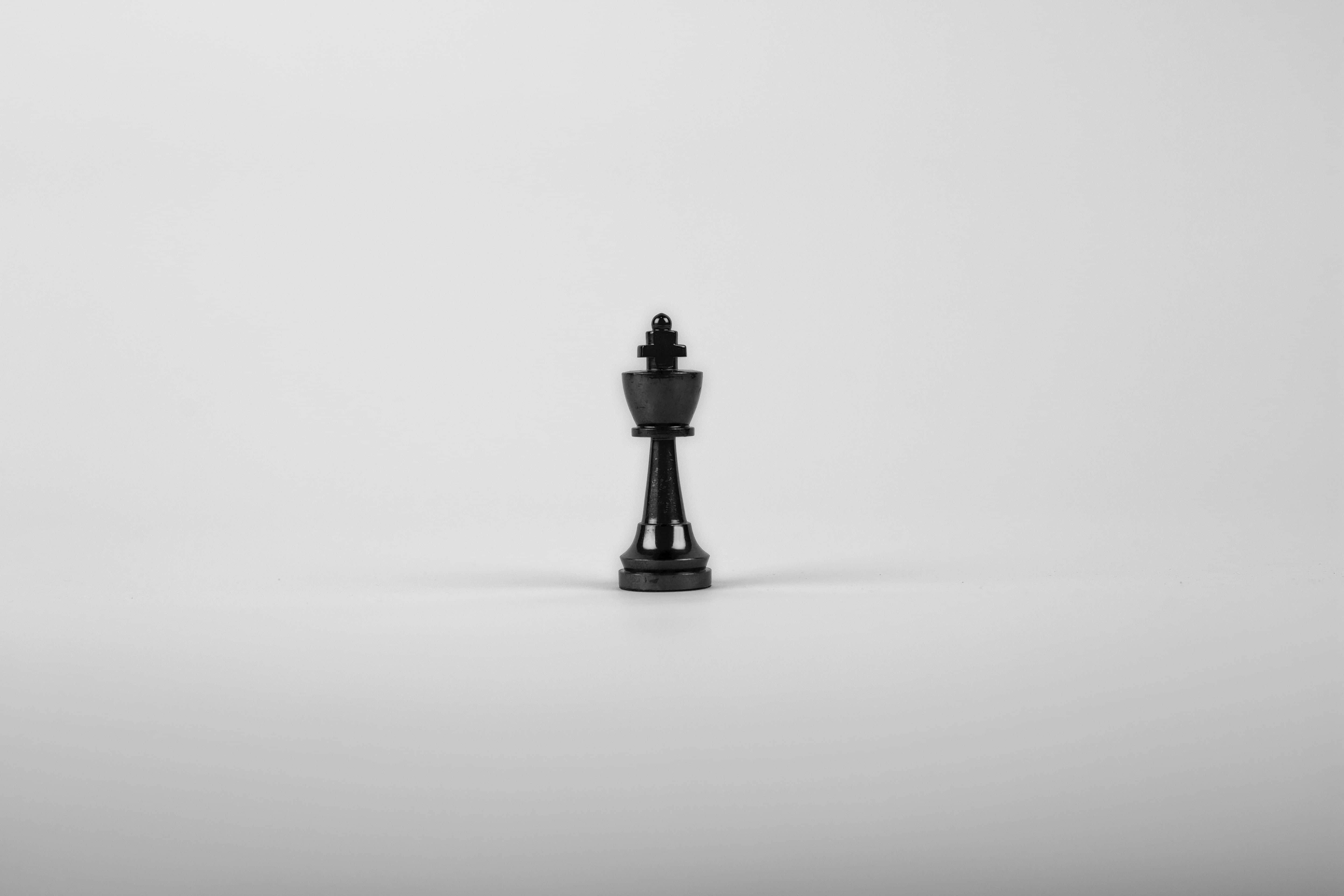 白色背景上的一枚黑色國際象棋棋子 壁紙