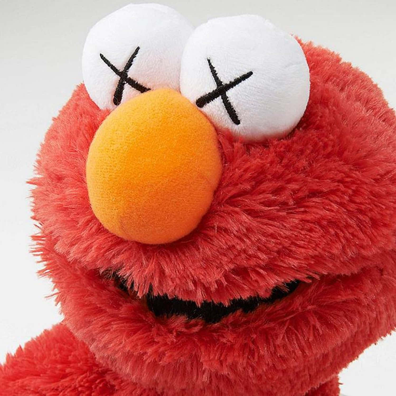Kaws Sesame Street 桌布 壁紙 — 白色背景前，紅色毛絨Elmo公仔的特寫，眼睛以X形縫製，鼻子為橙色。