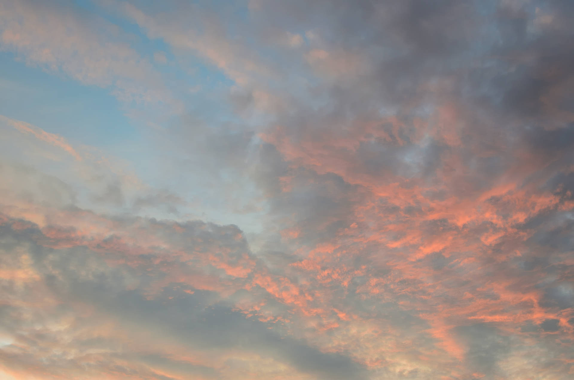 傍晚天空中充滿活力的橙色、粉紅色和藍色調的日落雲彩。