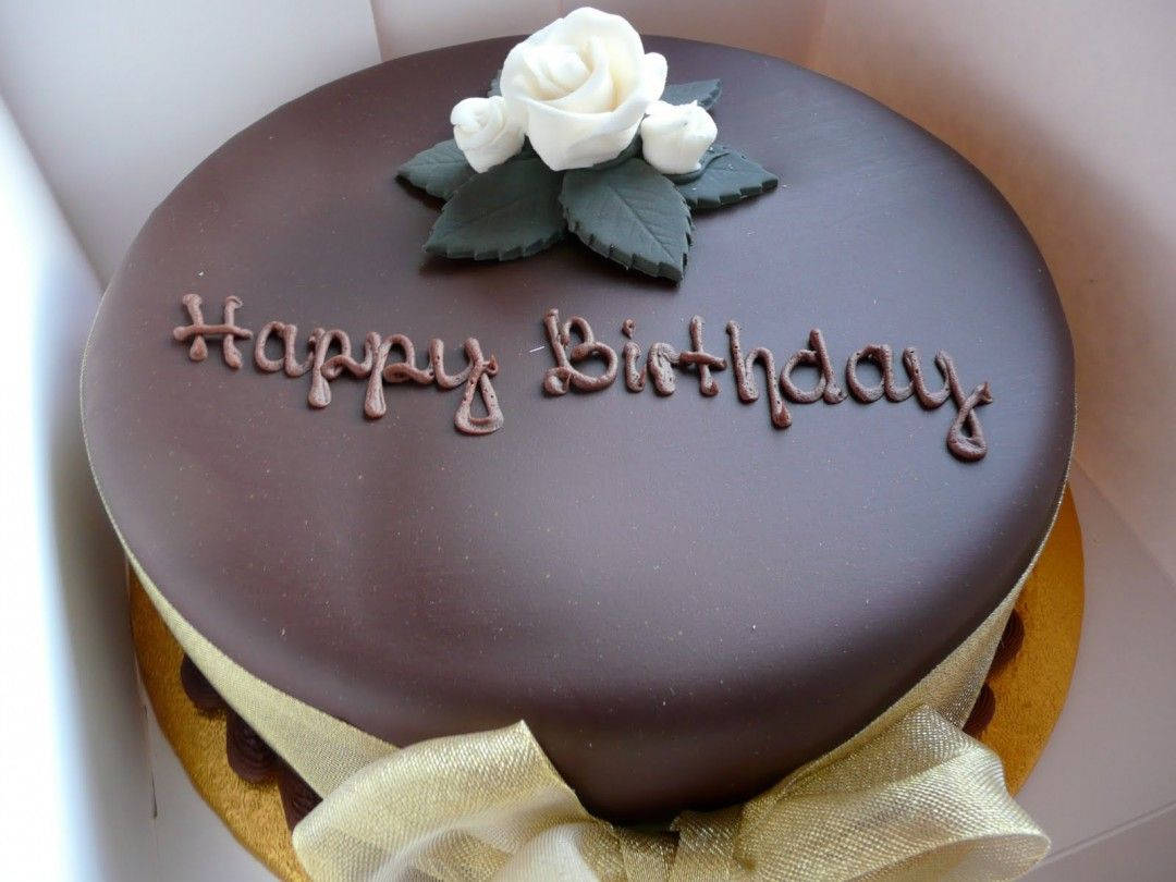 白色花朵裝飾生日蛋糕 壁紙 — 一個裝在盒子裡、飾有白玫瑰和金色絲帶的濃郁朱古力生日蛋糕。