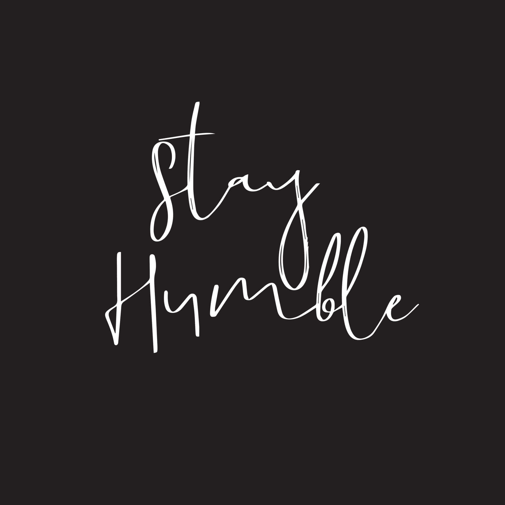 正面語錄 桌布 壁紙 — 白色草書文字 'Stay Humble' 居中顯示在純黑色背景上。