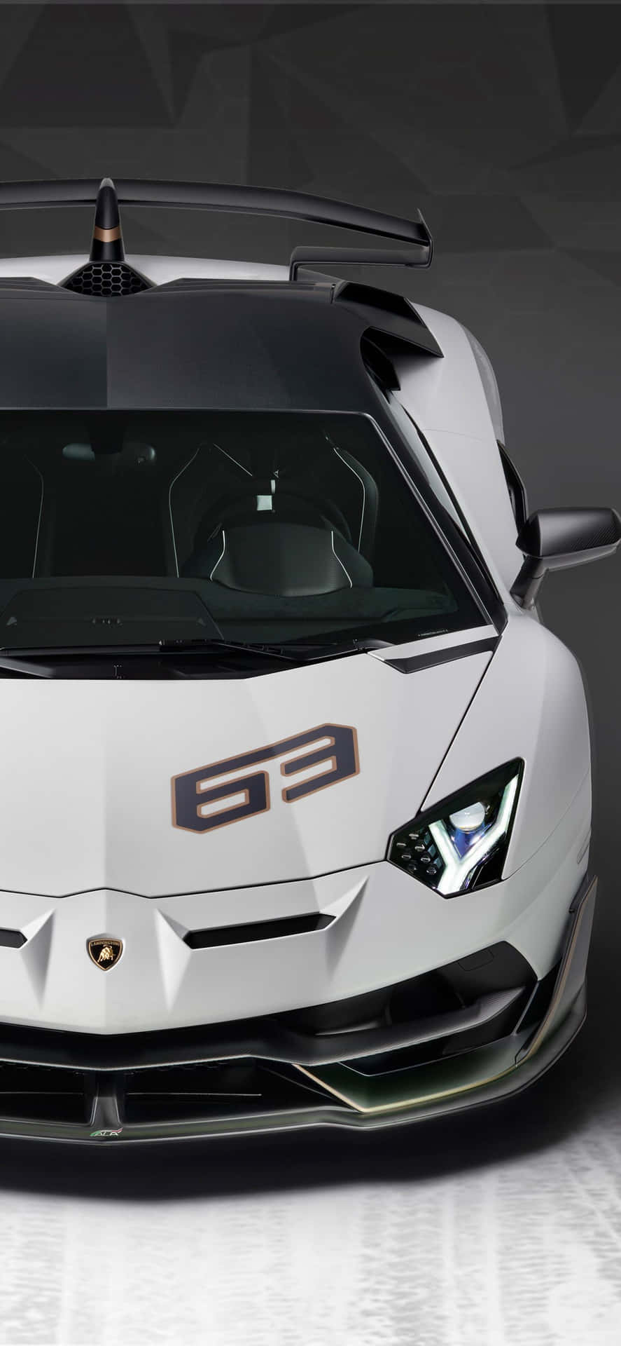 白色林寶堅尼 Aventador SVJ 63 跑車，帶有黑色飾邊和幾何背景。