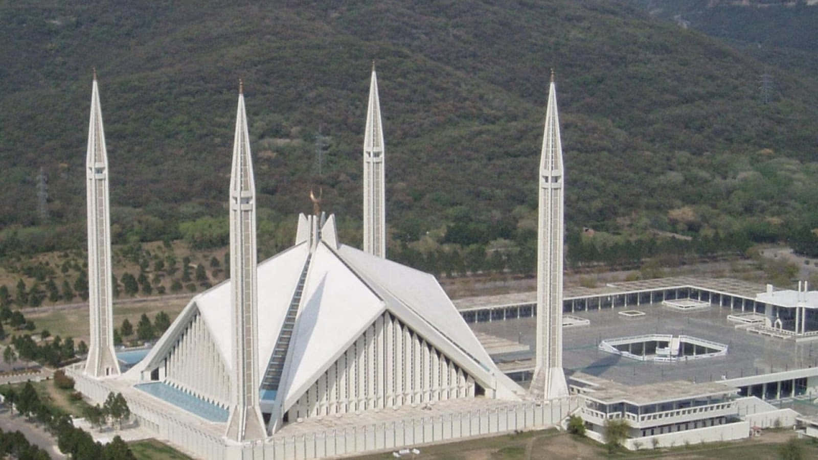 Pakistan 桌布 壁紙 — 白色費薩爾清真寺的鳥瞰圖，四座高聳的宣禮塔以森林覆蓋的山脈為背景。