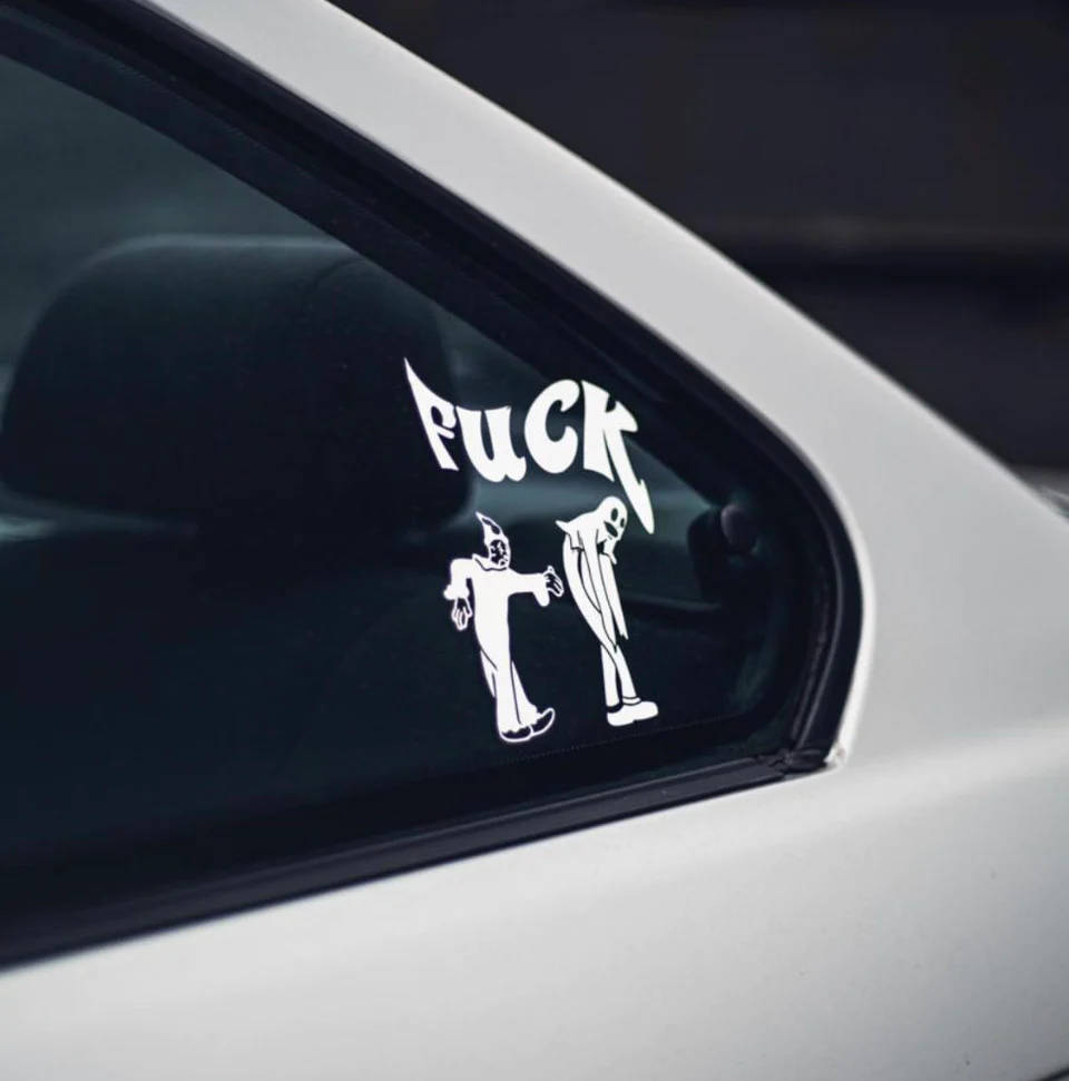 Ghostemane 桌布 壁紙 — 白色車窗上顯示一個粗體白色貼紙，上面有「FUCK」字樣，下方是兩個對峙姿勢的卡通人物。