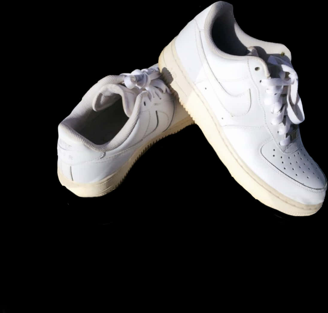 白色運動鞋配黑色背景 壁紙 — 兩對純白Nike Air Force 1波鞋喺強烈燈光下懸浮喺純黑背景之上。