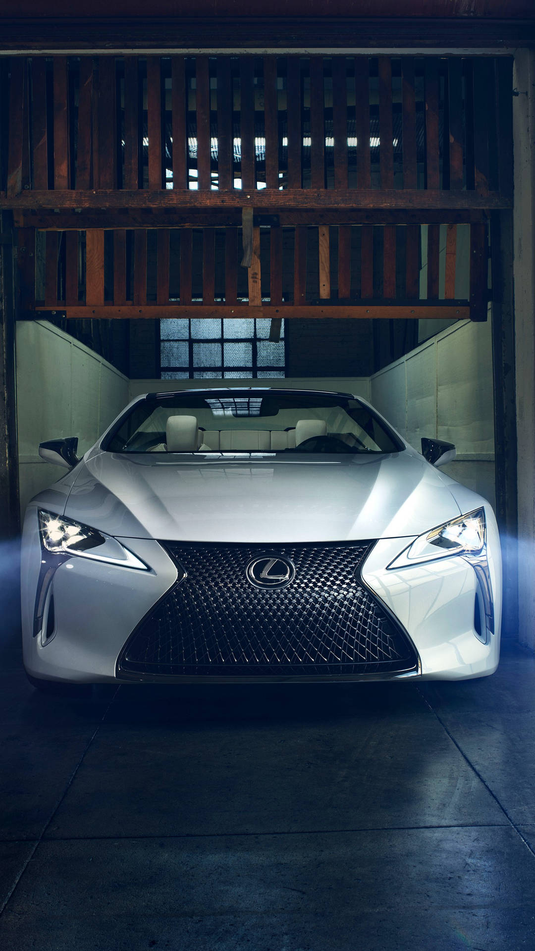 銀色Lexus跑車停放在木車庫內，帶有戲劇性的燈光。