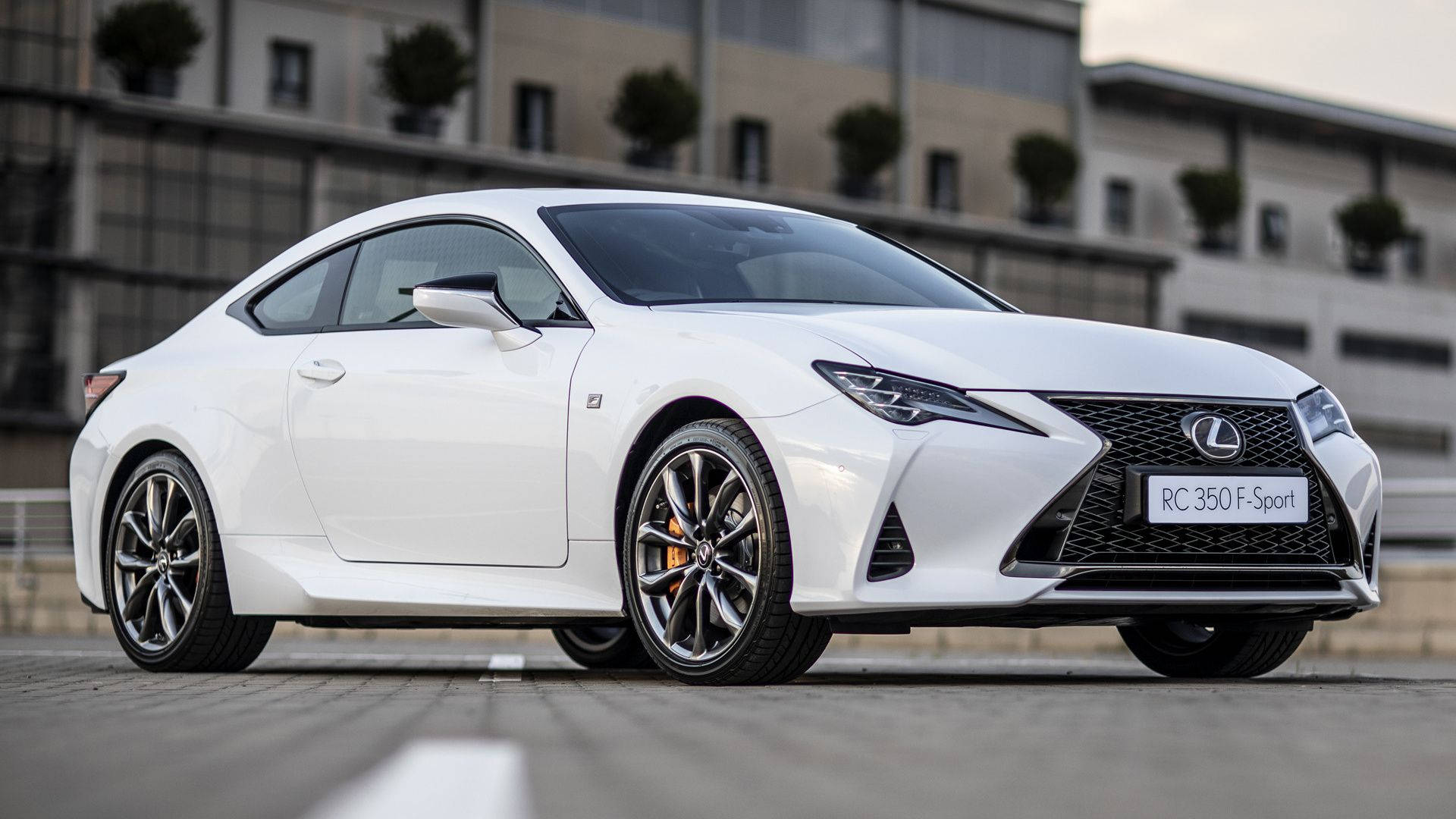 白色Lexus RC 350 F-Sport運動雙門轎跑車停放在現代建築附近的戶外。