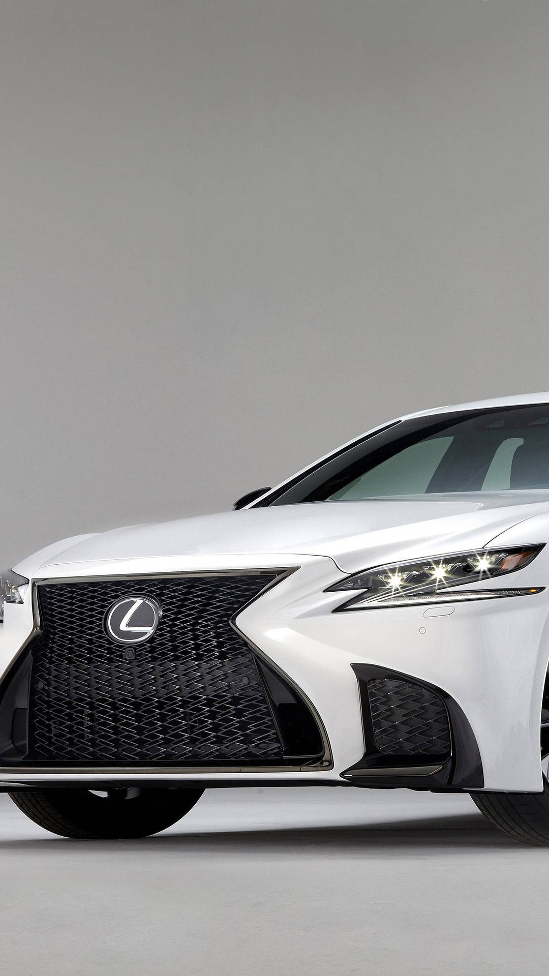 白色Lexus房車，在工作室環境中配備銳利頭燈和大膽格柵。