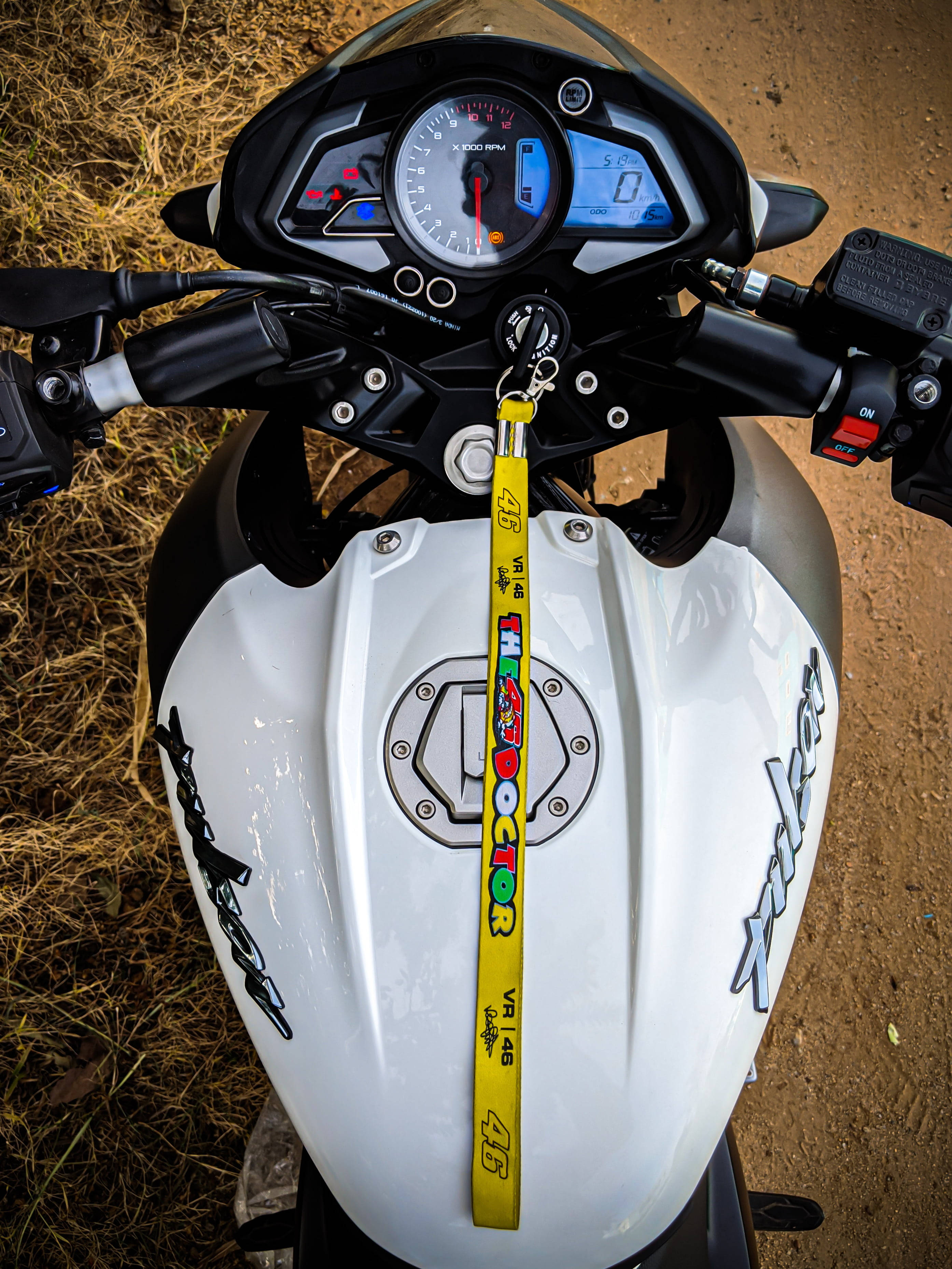 機車 桌布 壁紙 — 白色電單車的油缸和把手特寫，黃色VR46鎖匙扣掛在點火開關上。