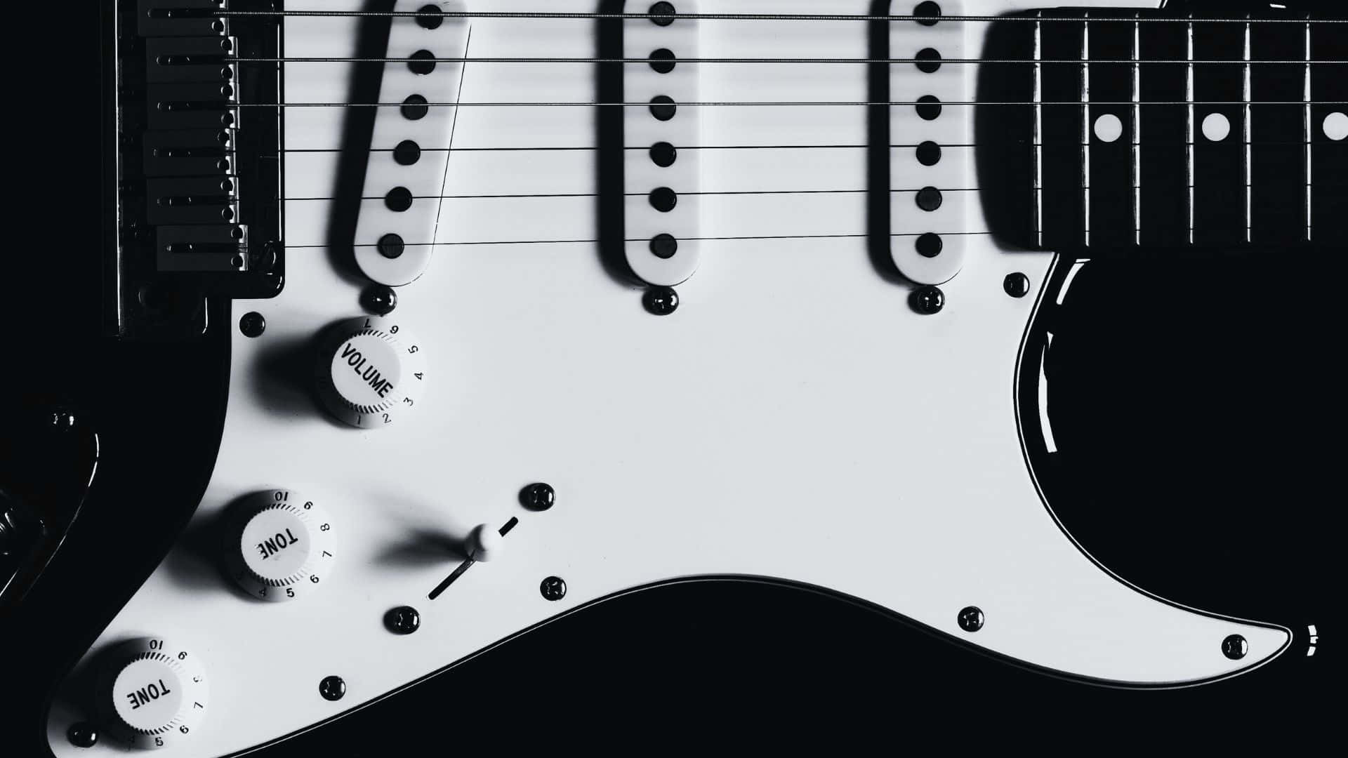 Black And White Guitar 桌布 壁紙 — 白色電結他的控制旋鈕和琴弦在深色背景上的特寫。