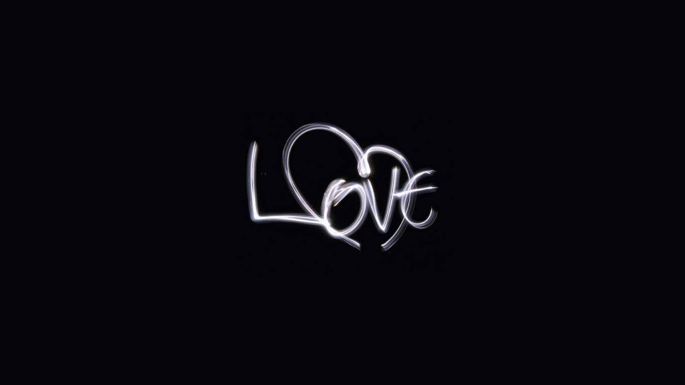 黑色背景上發光白色手寫字 love