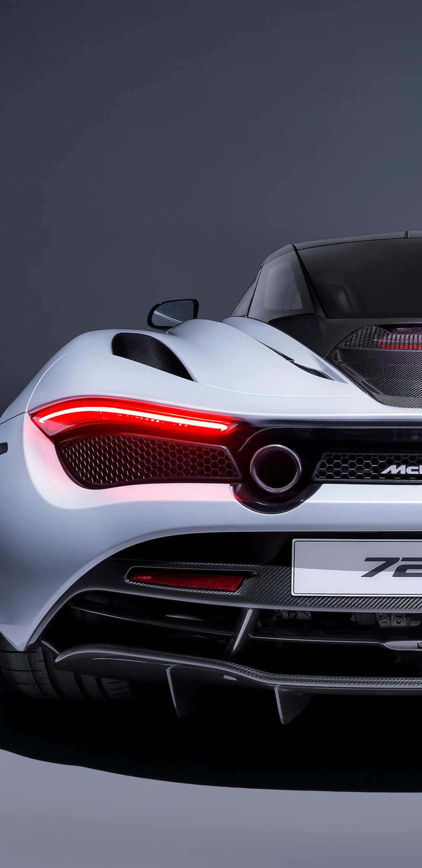 白色麥拉倫720S後視圖像素3XL背景 壁紙 — 特寫一輛銀色McLaren 720S跑車在黑暗工作室背景下的發光紅色尾燈。