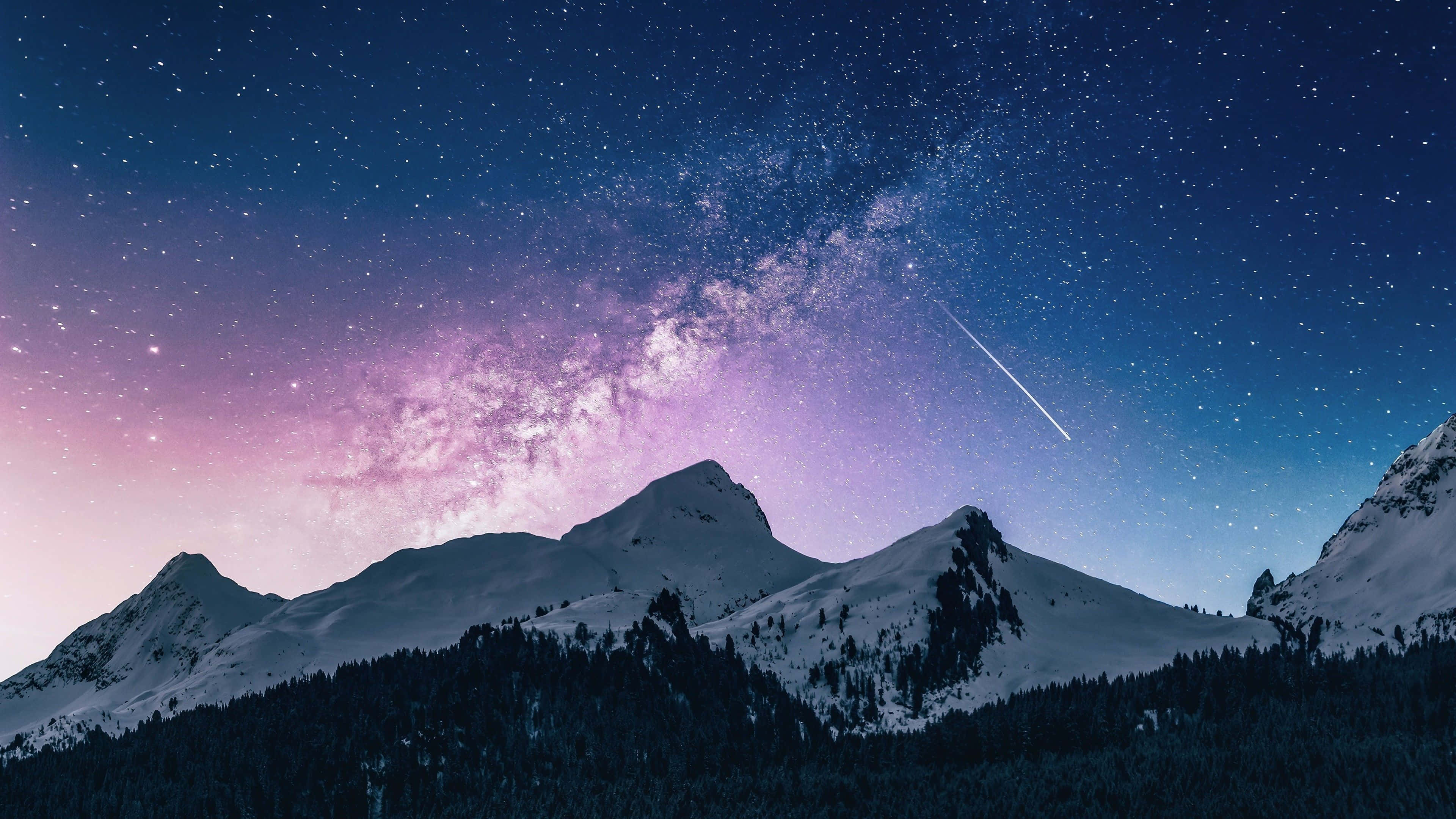 comet 桌布 壁紙 — 白雪覆蓋的山峰在充滿星星和明亮流星嘅紫色同藍色夜空下升起。