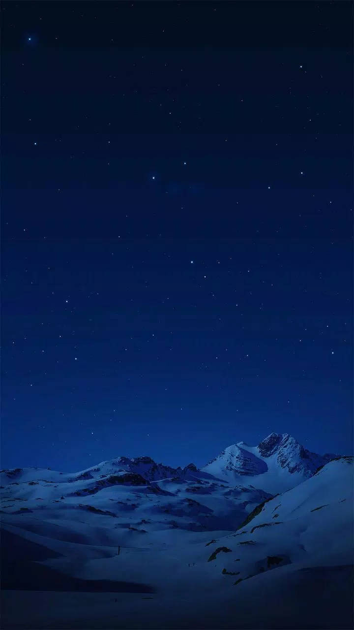 夜空 桌布 壁紙 — 白雪覆蓋的山峰在深藍色星空下聳立，滿天繁星閃爍。