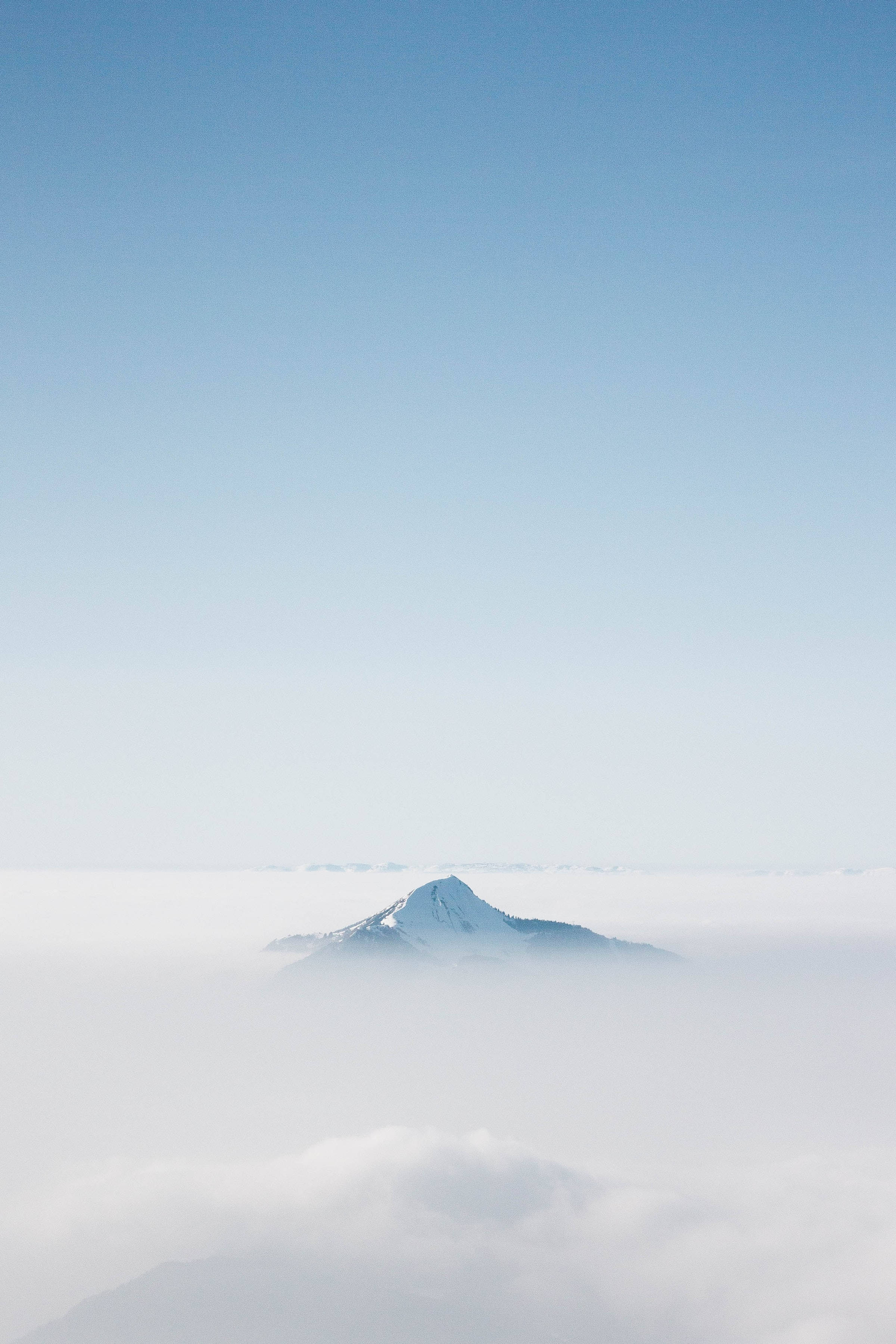 Clear 桌布 壁紙 — 白雪覆蓋的山峰在清澈的藍天下，雄偉地聳立在雲海之上。