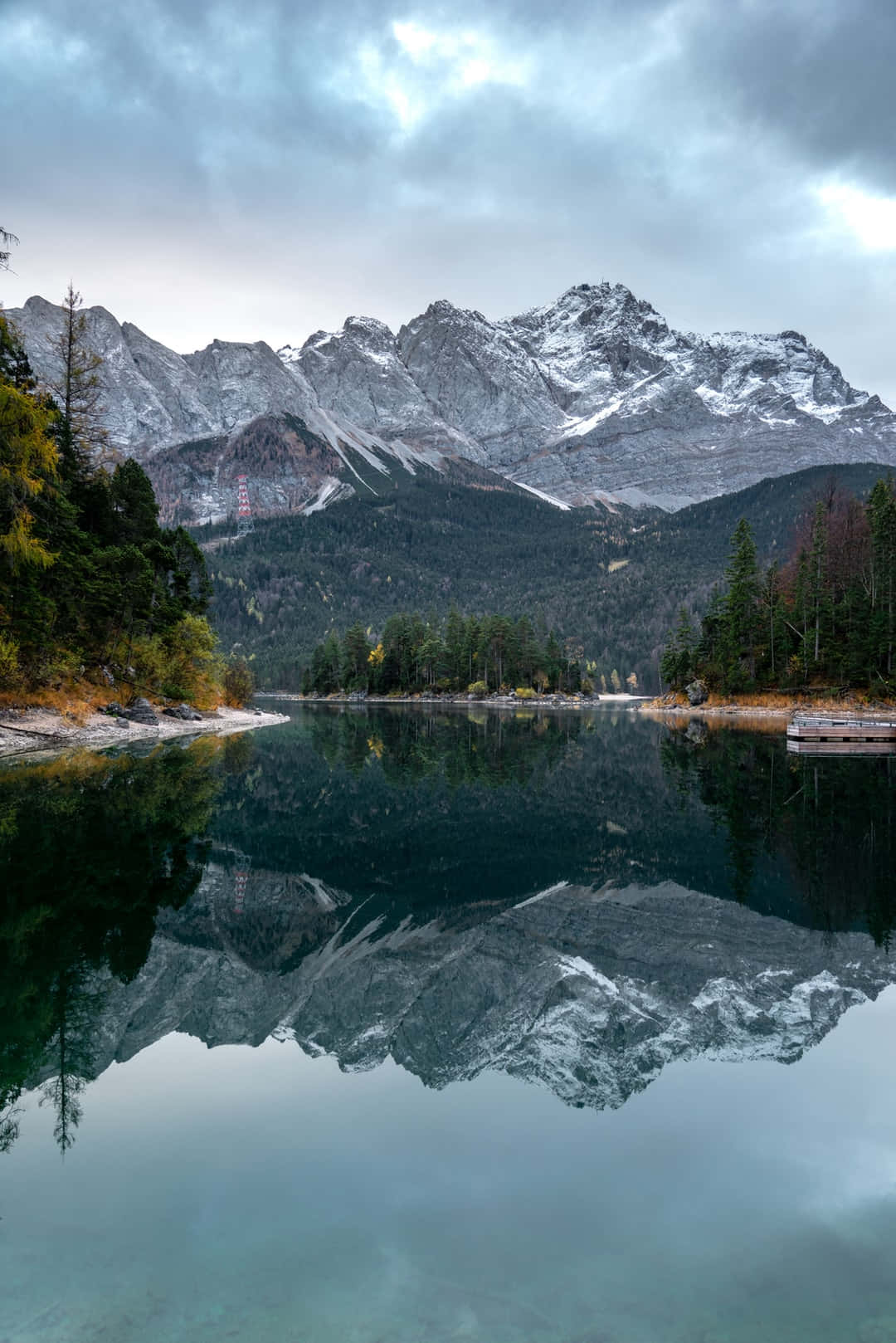 Picturesque 桌布 壁紙 — 白雪覆蓋的山峰在陰天之下，聳立於平靜的湖泊後方，湖面倒映著山巔。