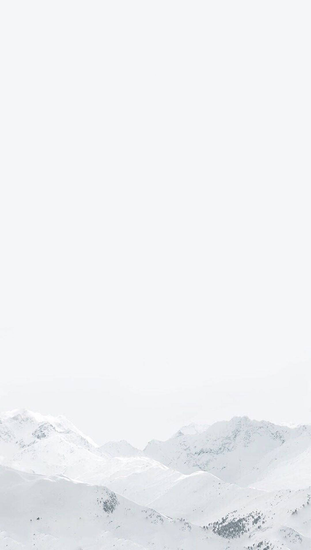 山脈 桌布 壁紙 — 白雪覆蓋的山峰從朦朧的白色天空中浮現，形成極簡的冬季景觀。