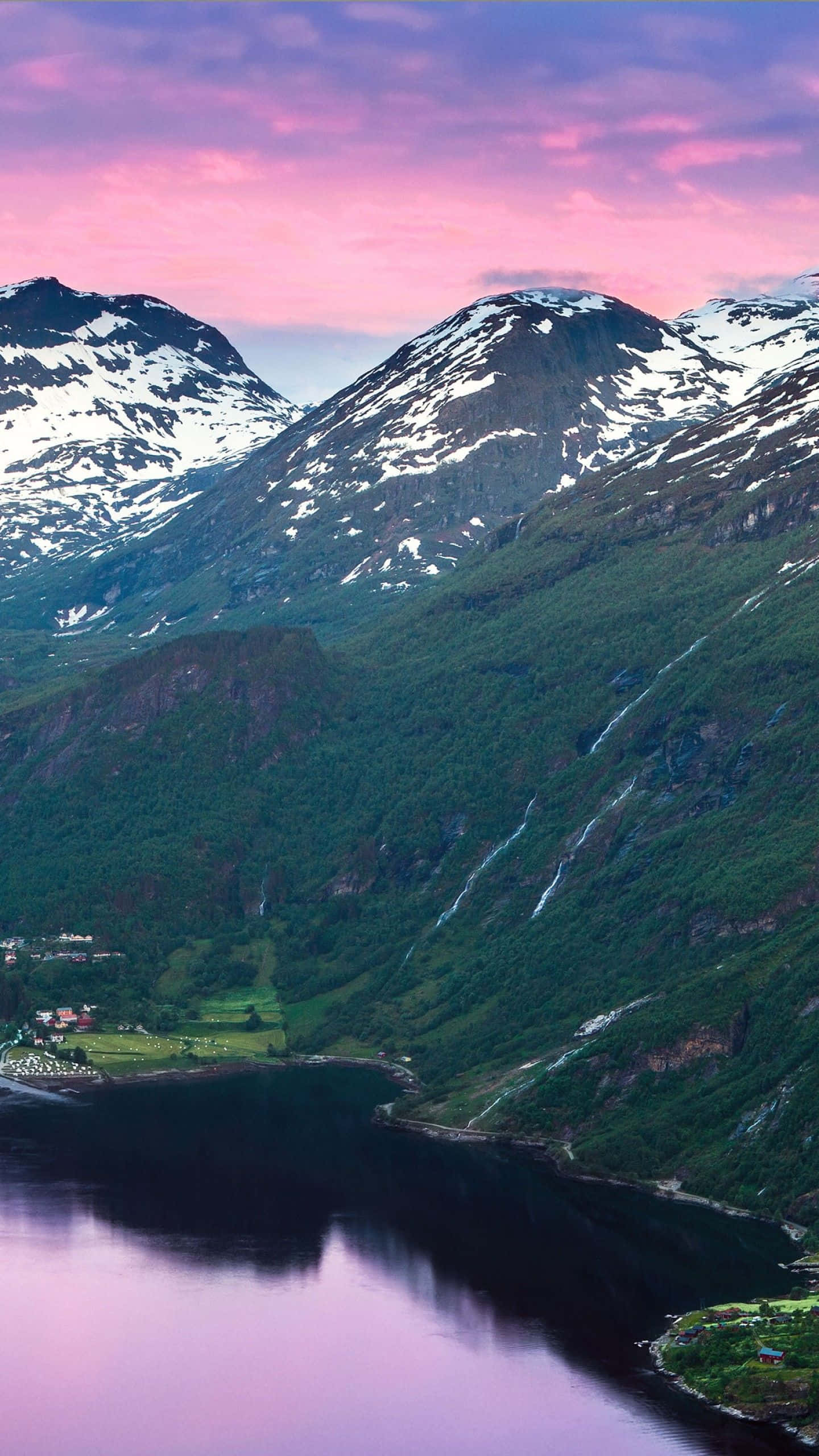 Norway 桌布 壁紙 — 白雪覆蓋的山脈在寧靜的峽灣中倒映，天空呈現鮮豔的粉紅色日落。