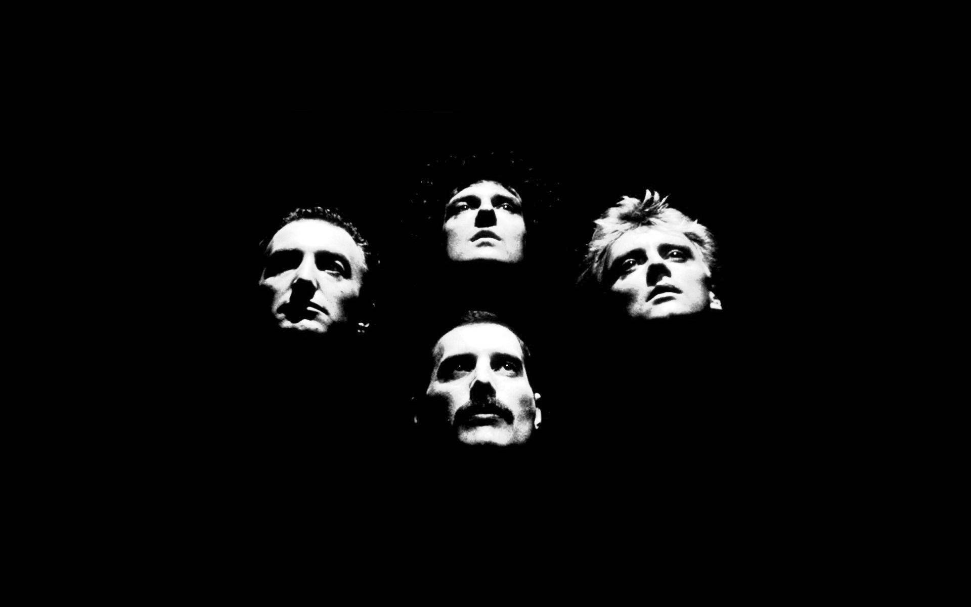 四個男人的臉在黑色背景下照明，向上凝視，表情強烈。