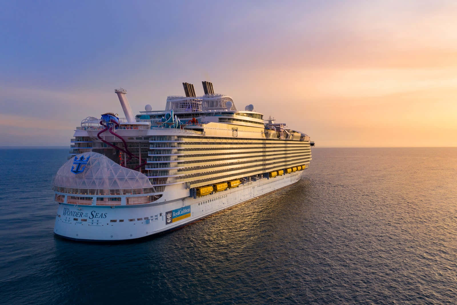 Cruise Ship 桌布 壁紙 — 皇家加勒比海洋奇蹟號郵輪在日落時分雄偉航行，金色光芒映照在平靜的海面上。