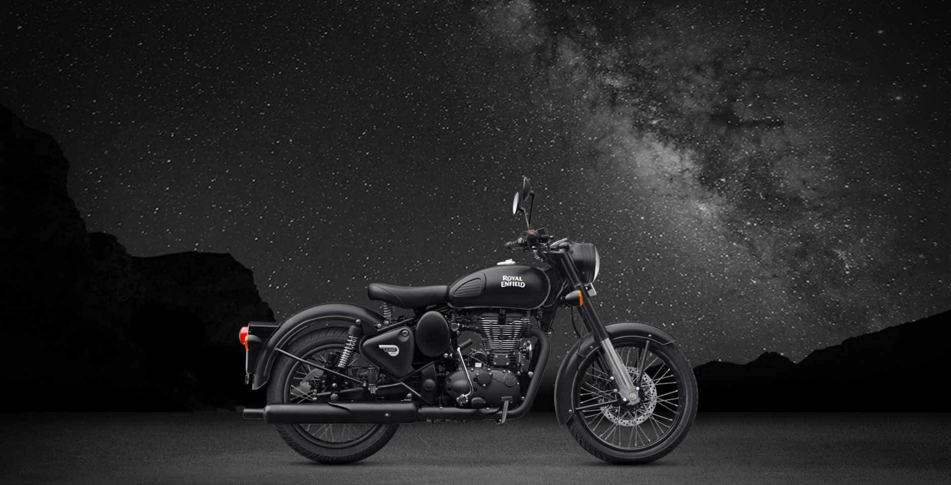 黑色 Royal Enfield 電單車在星空、銀河和山巒下。