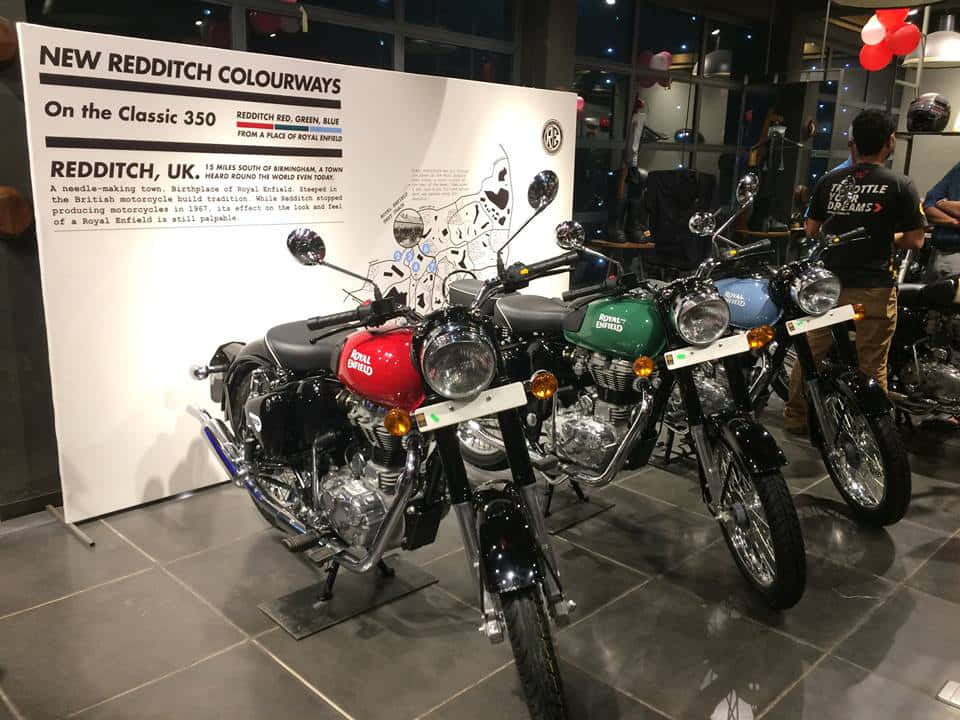 在陳列室中展示的三輛紅色、綠色和藍色的 Royal Enfield 電單車。